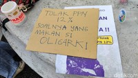 Poster-poster yang dibawa berisi penolakan PPN 12%.  