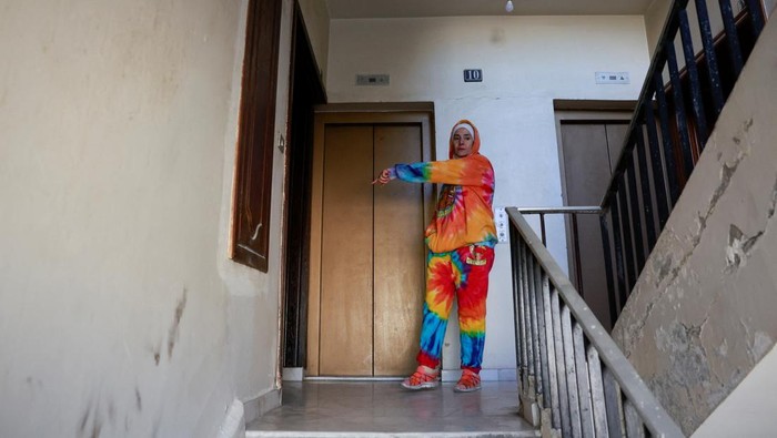 A woman shows where, according to residents, Syria's de facto leader Ahmed al-Sharaa, also known as Abu Mohammed al-Golani, lives in Damascus, Syria December 18, 2024. REUTERS/Ammar Awad