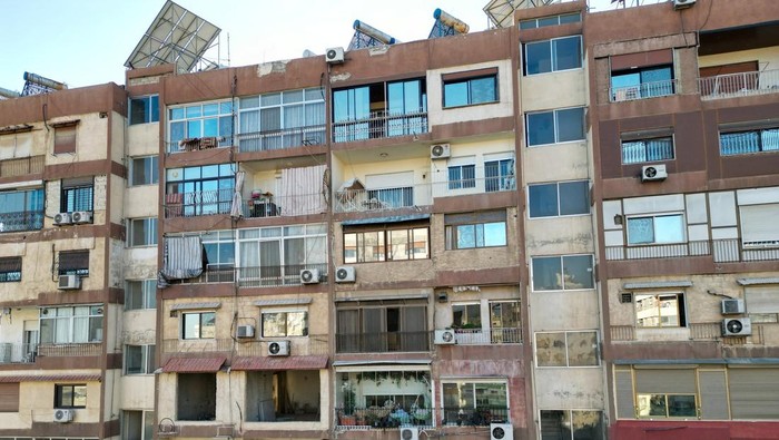 Ini Tempat Tinggal Pemimpin Baru Suriah A woman shows where, according to residents, Syria's de facto leader Ahmed al-Sharaa, also known as Abu Mohammed al-Golani, lives in Damascus, Syria December 18, 2024. REUTERS/Ammar Awad