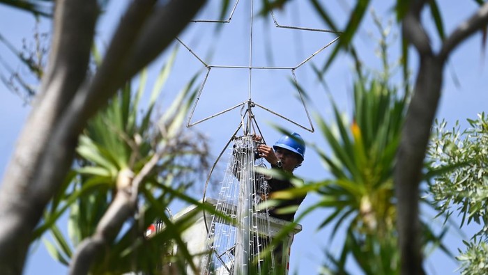 Petugas menyusun rangkaian lampu membentuk pohon Natal di kawasan wisata The Nusa Dua, Badung, Bali, Kamis (19/12/2024). Pemasangan berbagai dekorasi dan ornamen khas Natal tersebut dilakukan untuk menyambut para wisatawan dari berbagai negara yang berkunjung ke kawasan itu selama masa periode liburan Hari Raya Natal 2024 dan Tahun Baru 2025. ANTARA FOTO/Fikri Yusuf/aww.