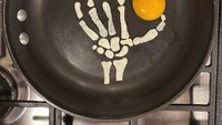 Tingkat kreativitas Baldini juga tak berhenti di situ saja, ia juga membuat karakter berbentuk tengkorak tangan dari putih telur. Tengkorak tangan itu seperti membentuk simbol Oke dengan bagian jempolnya diberikan kuning telur. Foto: Instagram @the_eggshibit