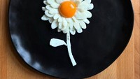 Telur ceplok berbentuk bunga ini terlihat sangat cantik. Ia membuat kelopak bunga dengan putih telur yang berlapis, kemudian bagian tengahnya diberikan kuning telur bulat utuh. Foto: Instagram @the_eggshibit