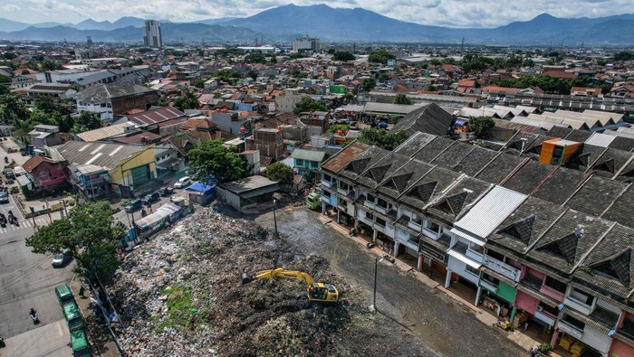 Permasalahan sampah di Pasar Induk Caringin Alat berat yang dioperasikan petugas meratakan sampah yang menumpuk di Pasar Induk Caringin, Bandung, Jawa Barat, Kamis (19/12/2024). Sampah yang menumpuk berbulan-bulan di Pasar Induk Caringin tersebut disebabkan minimnya ritase angkutan sampah, dan warga berharap agar Pemerintah Kota Bandung segera menyelesaikan permasalahan itu karena bau sampah tercium hingga permukiman. ANTARA FOTO/Raisan Al Farisi/Spt.