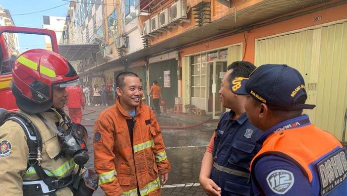 Petugas memadamkan kebakaran ruko di Surabaya