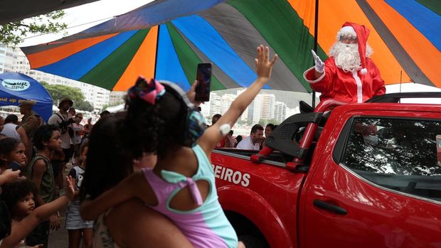 Firefighter Thiago Paiva, dressed as Santa Claus, rides on a jet ski during Christmas season celebrations in Copacabana beach in Rio de Janeiro, Brazil December 17, 2024. REUTERS/Pilar Olivares