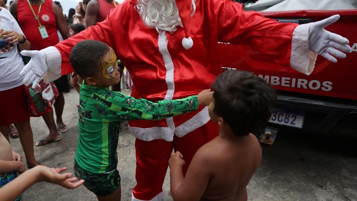 Aksi Sinterklas di Brasil Antar Hadiah Naik Jet Ski Firefighter Thiago Paiva, dressed as Santa Claus, rides on a jet ski during Christmas season celebrations in Copacabana beach in Rio de Janeiro, Brazil December 17, 2024. REUTERS/Pilar Olivares