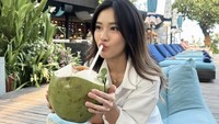 Jessica Jane juga menunjukkan momen ketika sedang santai di salah satu beach club. Ia duduk sambil menyeruput kelapa muda segar. Foto: Instagram @jessicajane99