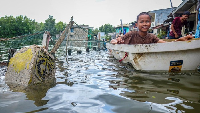 Dua anak bermain saat banjir rob di kawasan Marunda Pulo, Jakarta, Rabu (4/12/2024). Badan Penanggulangan Bencana Daerah (BPBD) DKI Jakarta memperkirakan banjir akibat kenaikan permukaan air laut masih akan terjadi di sejumlah titik rawan wilayah pesisir Jakarta Utara hingga 20 Desember 2024. ANTARA FOTO/Idlan Dziqri Mahmudi/fzn/rwa.