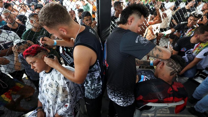 Men with colour-treated hair sit during a barbers' battle contest for best haircut in Rio de Janeiro, Brazil December 15, 2024. REUTERS/Aline Massuca