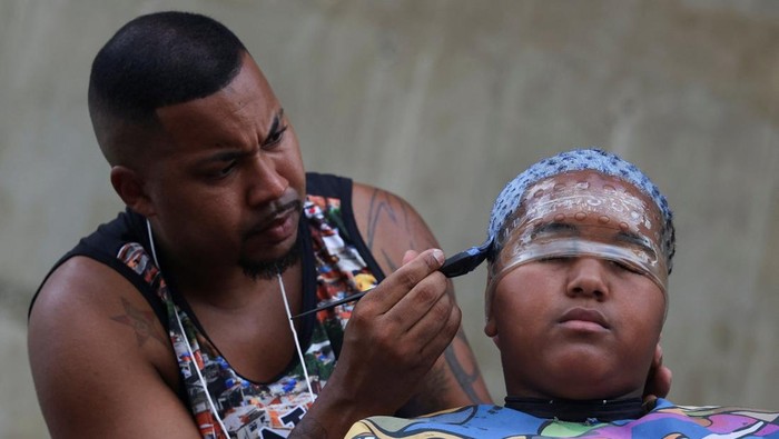 Men with colour-treated hair sit during a barbers' battle contest for best haircut in Rio de Janeiro, Brazil December 15, 2024. REUTERS/Aline Massuca