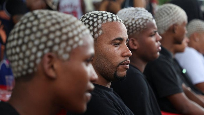 Men with colour-treated hair sit during a barbers' battle contest for best haircut in Rio de Janeiro, Brazil December 15, 2024. REUTERS/Aline Massuca