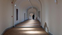 Seorang pengunjung berjalan menyusuri Koridor Vasari, lorong era Renaisans yang dibangun oleh arsitek abad ke-16 sekaligus pelukis Giorgio Vasari, di Florence, Italia, Kamis (19/12).