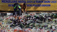 Belasan ribu botol miras dimusnahkan dengan cara digilas alat berat.