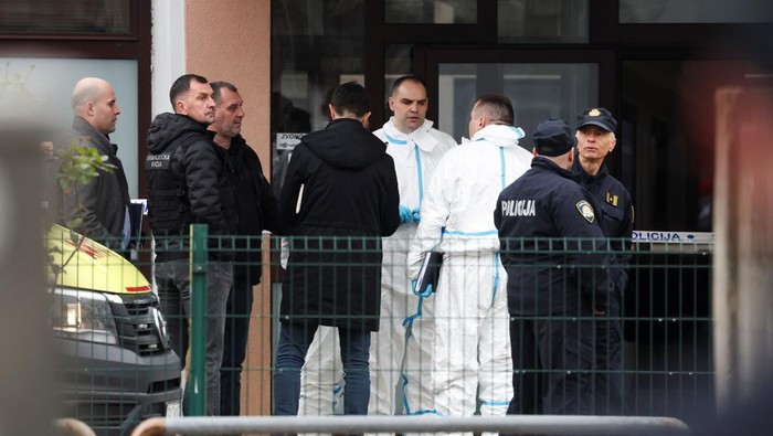 People stand near an ambulance, following a knife attack in a primary school, in Zagreb, Croatia, December 20, 2024. REUTERS/Antonio Bronic