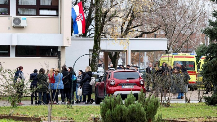 People stand near an ambulance, following a knife attack in a primary school, in Zagreb, Croatia, December 20, 2024. REUTERS/Antonio Bronic