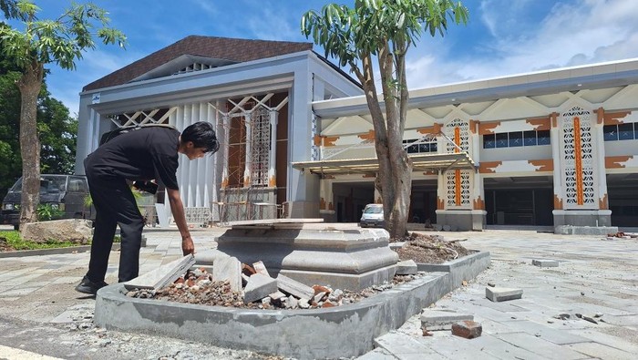 Seorang warga melihat bongkahan Tugu Perang Lombok masa penjajahan Belanda 1894 yang ditemukan di halaman Kantor Gubernur NTB, Jumat (20/12/2024). (Nathea Citra/detikBali)