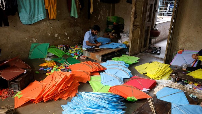 Mohammad Yunus, a kite maker, along with a worker checks the quality of kites before packing them inside a workshop in Ahmedabad, India, December 29, 2023. REUTERS/Amit Dave
