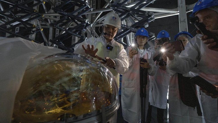 Wujud Detektor Raksasa China untuk Cari Partikel Hantu Workers labor on the underside of the cosmic detector located 2297 feet (700 meters) underground at the Jiangmen Underground Neutrino Observatory in Kaiping, southern Chinas Guangdong province on Friday, Oct. 11, 2024. (AP Photo/Ng Han Guan)