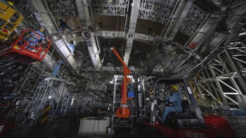 Para pekerja bekerja di bagian bawah detektor kosmik yang terletak 2.297 kaki (700 meter) di bawah tanah di Observatorium Neutrino Bawah Tanah Jiangmen di Kaiping, provinsi Guangdong, China selatan. Detektor neutrino baru di China bertujuan untuk menemukan partikel hantu misterius yang mengintai di sekitar kita.