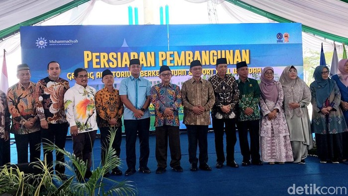 Menteri Pendidikan Dasar dan Menengah Abdul Muti, Ketua Umum PP Muhammadiyah Haedar Nashir dan sejumlah orang lainnya berfoto usai acara grounbreaking. (Finta Rahyuni/detikSumut)