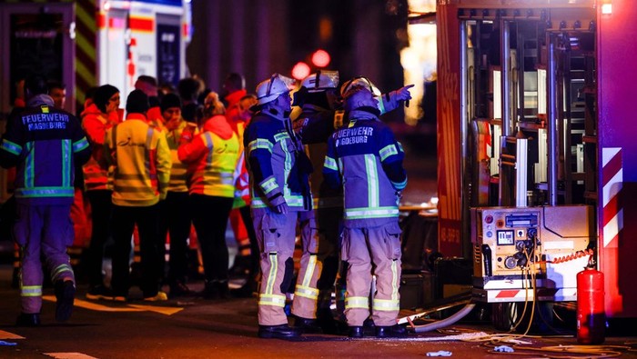 Emergency personnel stand next to a damaged car that drove into a group of people, according to local media, in Magdeburg, Germany, December 21, 2024. REUTERS/Axel Schmidt