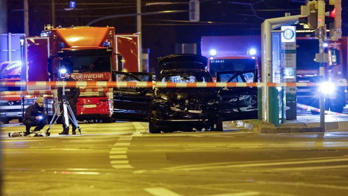 Emergency personnel stand next to a damaged car that drove into a group of people, according to local media, in Magdeburg, Germany, December 21, 2024. REUTERS/Axel Schmidt