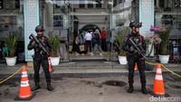 Polisi bersenjata laras panjang berjaga di depan Stasiun Pasar Senen, Jakarta, Sabtu (21/12/2024).