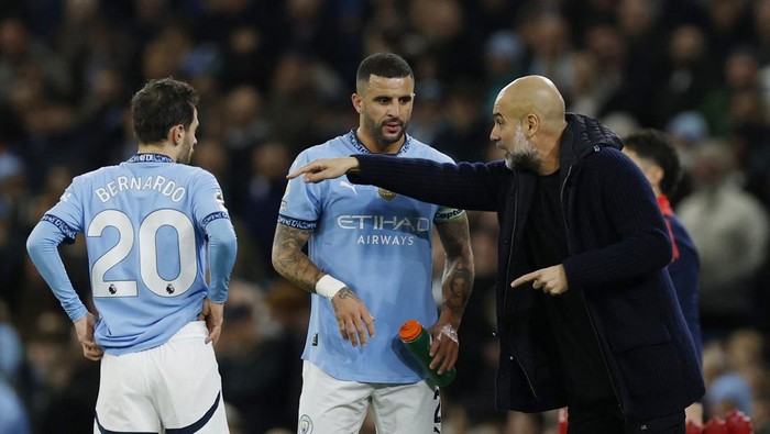 Soccer Football - Premier League - Manchester City v Manchester United - Etihad Stadium, Manchester, Britain - December 15, 2024 Manchester City manager Pep Guardiola speaks to Kyle Walker and Bernardo Silva during a break in play Action Images via Reuters/Jason Cairnduff EDITORIAL USE ONLY. NO USE WITH UNAUTHORIZED AUDIO, VIDEO, DATA, FIXTURE LISTS, CLUB/LEAGUE LOGOS OR LIVE SERVICES. ONLINE IN-MATCH USE LIMITED TO 120 IMAGES, NO VIDEO EMULATION. NO USE IN BETTING, GAMES OR SINGLE CLUB/LEAGUE/PLAYER PUBLICATIONS. PLEASE CONTACT YOUR ACCOUNT REPRESENTATIVE FOR FURTHER DETAILS..
