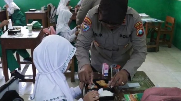 Polresta Malang Kota membagikan makanan bergizi.