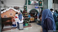 Penumpang di instalasi Natal yang menghiasi Stasiun Pasar Senen Jakarta.