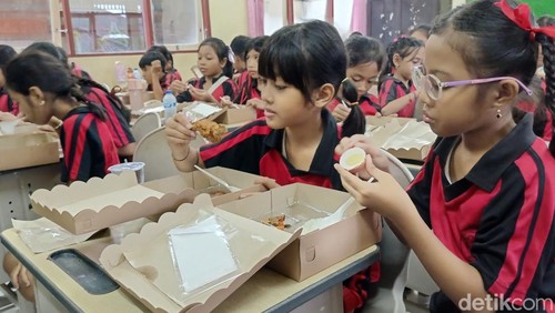 Siswa di SDN 17 Dangin Puri Denpasar, Bali saat menikmati makan bergizi gratis dari Disdikpora Kota Denpasar pada Sabtu (21/12/2024). (Ni Made Lastri Karsiani Putri-detikBali)