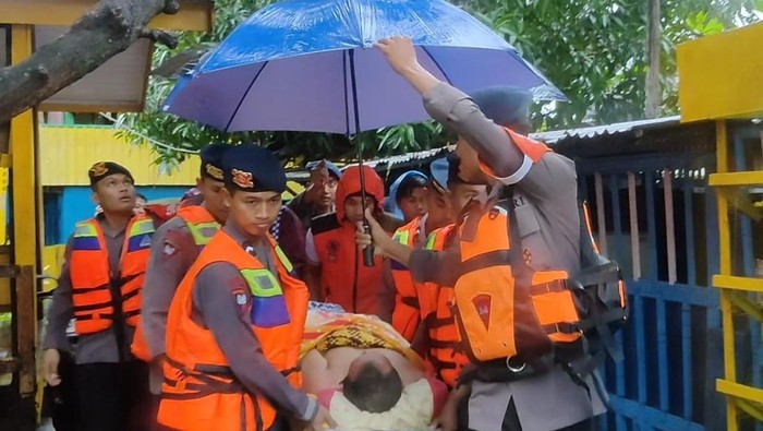 Tim SAR Batalyon B Pelopor Brimob mengevakuasi warga Parepare yang sakit di tengah kondisi banjir.