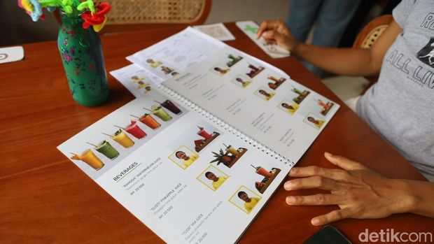 Daftar menu makanan di Piduh Charity Cafe yang memuat foto penyandang disabilitas yang ada di Yayasan Widya Guna Bali. (Foto: Firga Raditya Pamungkas/detikBali)