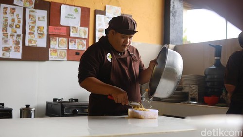 Dela, penyandang disabilitas down syndrom saat bekerja sebagai koki di Piduh Charity Cafe, Desa Bedulu, Kecamatan Blahbatuh, Gianyar, Bali,  Rabu (11/12/2024). (Foto: Firga Raditya Pamungkas/detikBali)