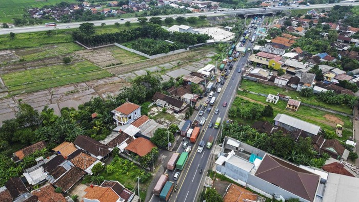 Foto udara kepadatan arus lalu lintas truk saat melintas di jalan Pantura Gringsing, Kabupaten Batang, Jawa Tengah, Minggu (22/12/2024). Kasat Lantas Polres Batang AKP Wigiyadi menyatakan kepadatan truk di jalan tersebut terjadi usai dilakukan penyekatan menuju arah Weleri Kendal yang berimbas kemacetan truk hingga ke Kabupaten Batang akibat dampak dari pembatasan truk angkutan barang saat libur Natal 2024 dan Tahun Baru 2025. ANTARA FOTO/Harviyan Perdana Putra/agr