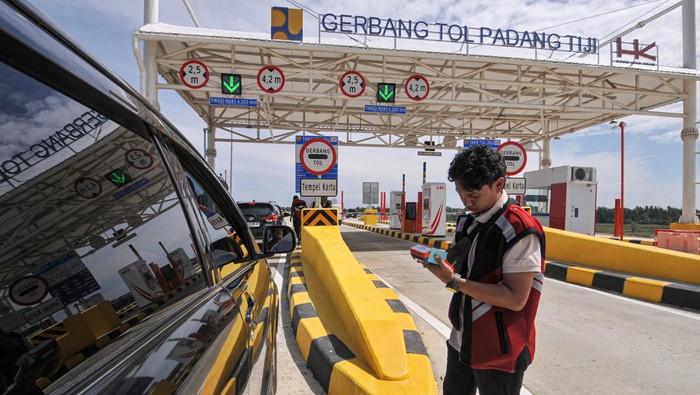 Petugas PT Hutama Karya (Persero) membantu pengisian ulang saldo e-money pengendara saat keluar Gerbang Tol Padang Tiji Jalan Tol Trans Sumatera (JTTS) ruas Sigli-Banda Aceh (Sibanceh) di Pidie, Aceh, Minggu (22/12/2024). PT Hutama Karya (Persero) membuka secara fungsional JTTS ruas Sigli-Banda Aceh seksi 1 (Padang Tiji-Seulimeum) sepanjang 24,67 kilometer dengan menerapkan tarif gratis mulai 21 Desember 2024 hingga 2 Januari 2025 dalam mendukung kelancaran arus lalulintas selama libur Natal dan Tahun Baru 2025.