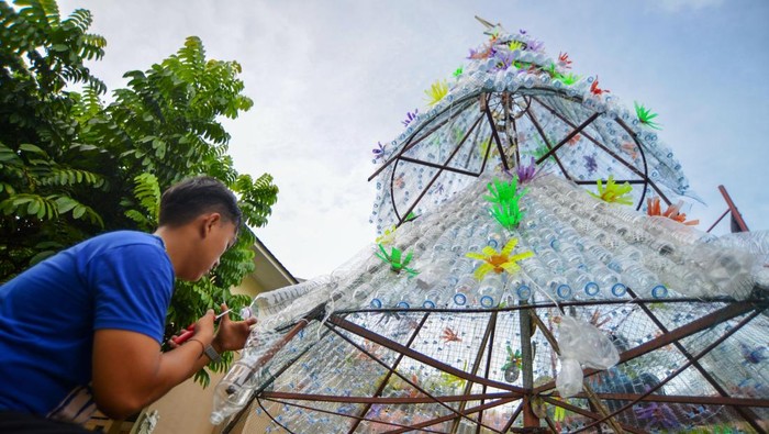 Sejumlah pemuda menyelesaikan pembuatan pohon natal dari botol plastik bekas di halaman Gereja Katedral ST Theresia Padang, Sumatera Barat, Sabtu (21/12/2024). Pemuda yang tergabung dalam Orang Muda Katolik (OMK) di gereja itu menyusun sedikitnya 1.500 botol plastik bekas  menjadi bentuk pohon Natal setinggi 6,5 meter sekaligus mengampanyekan peduli lingkungan dengan memanfaatkan barang yang bisa didaur ulang. ANTARA FOTO/Iggoy el Fitra/rwa.