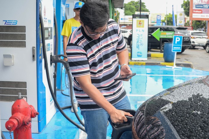 Pengendara memindai kode batang untuk registrasi pengisian daya baterai mobil di Stasiun Pengisian Kendaraan Listrik Umum (SPKLU) di rest area KM 57 Tol Jakarta-Cikampek, Kabupaten Karawang, Jawa Barat, Minggu (22/12/2024). PT PLN (Persero) menyiagakan 2490 SPKLU yang tersebar di 1745 lokasi di seluruh Indonesia selama periode Natal dan Tahun Baru 2025. ANTARA FOTO/Fakhri Hermansyah/Spt.