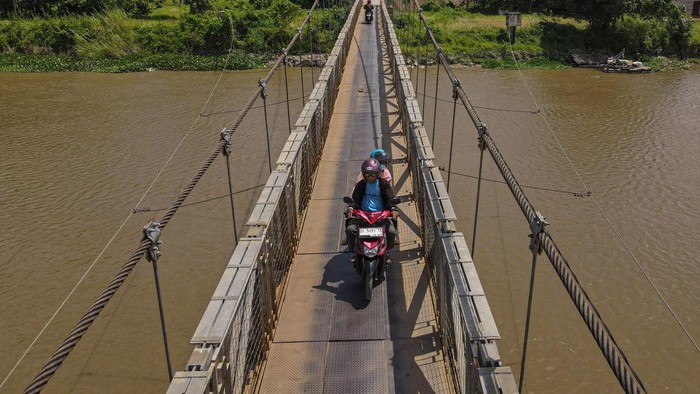 Potret Jembatan Gantung untuk Pangkas Waktu di Konawe Foto udara jembatan gantung Laosu di Kecamatan Kapoiala, Kabupaten Konawe, Sulawesi Tenggara, Minggu (22/12/2024). Jembatan sepanjang 120 meter dengan lebar 2 meter yang dibangun Balai Pelaksanaan Jalan Nasional (BPJN) Sulawesi Tenggara dengan anggaran sebesar Rp4,7 miliar tersebut menjadi pilihan bagi masyarakat setempat sebab mampu memangkas waktu tempuh menuju tiga Kecamatan di Kabupaten Konawe yakni Kecamatan Kapoiala, Morosi dan Bondoala.