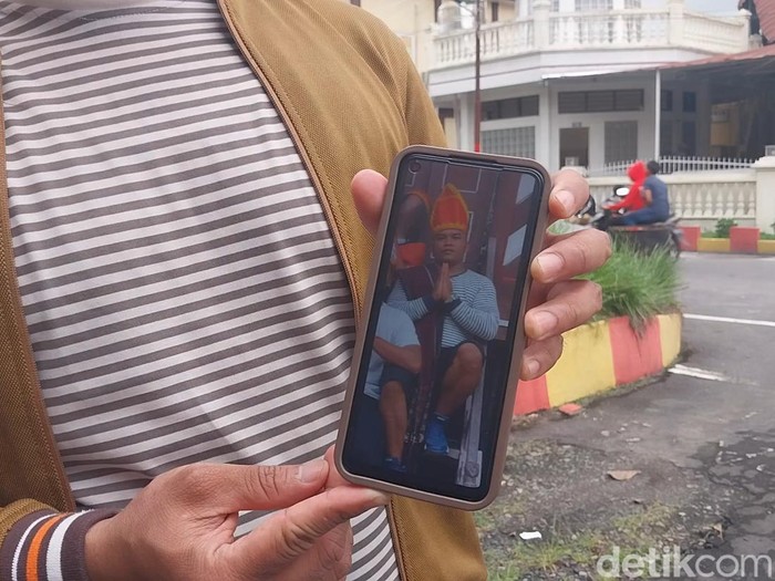 Adik korban, Anggito Sianipar saat menunjukkan foto korban.