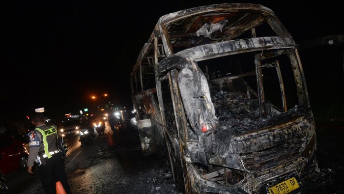 Petugas pemadam kebakaran menyemprotkan cairan saat pendinginan pada bangkai bus pascakebakaran di jalan Solo-Yogyakarta, Delanggu, Klaten, Jawa Tengah, Minggu (22/12/2024). Kebakaran bus yang mengangkut rombongan wisata itu tidak ada korban jiwa dan polisi masih menyelidiki penyebabnya. ANTARA FOTO/Aloysius Jarot Nugroho/agr