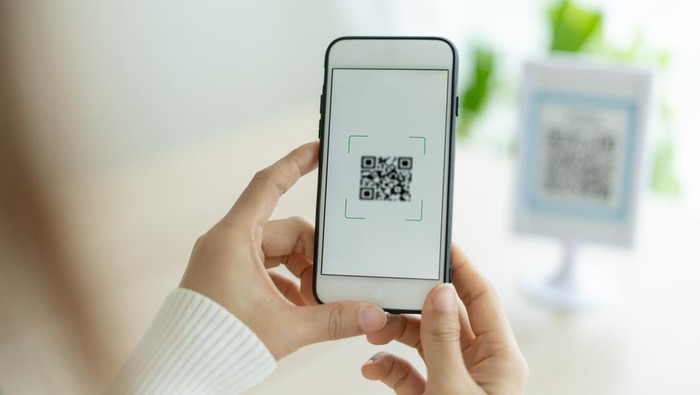 Modern woman use phone to scan barcode or QR codes to pay credit card bill after receive document invoice. payment, receive, paying electricity, digital payments without money, technology, scanning