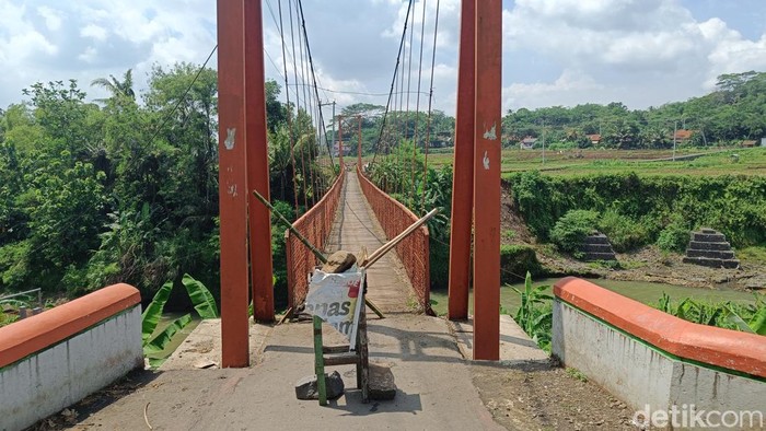 Kondisi jembatan gantung penghubung Desa Sidabowa-Karanganyar, Kecamatan Patikraja, Kabupaten Banyumas yang ditutup imbas dari longsornya bantaran penyangga pondasi, Senin (23/12/2024).