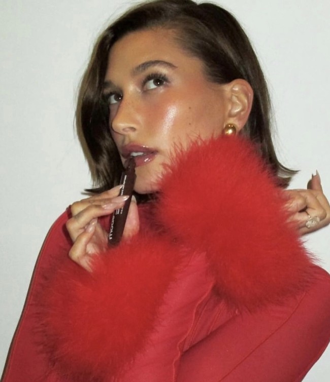 Glossy and Glowy  Siapa yang tidak ingin kulit terlihat sehat dan glowing sepanjang waktu? Ambil inspirasi dari Hailey Bieber dengan tampilan glazed skin. Untuk Natal, gunakan lip tint espresso sheer (kecoklatan) yang memberikan sentuhan hangat, serta blush on cair warna plum pada pipi untuk kesan segar dan bercahaya. Foto: dok. Instagram maryphillips