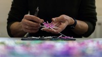 Perajin merakit manik-manik kaca tiup menjadi ornamen hiasan Natal.