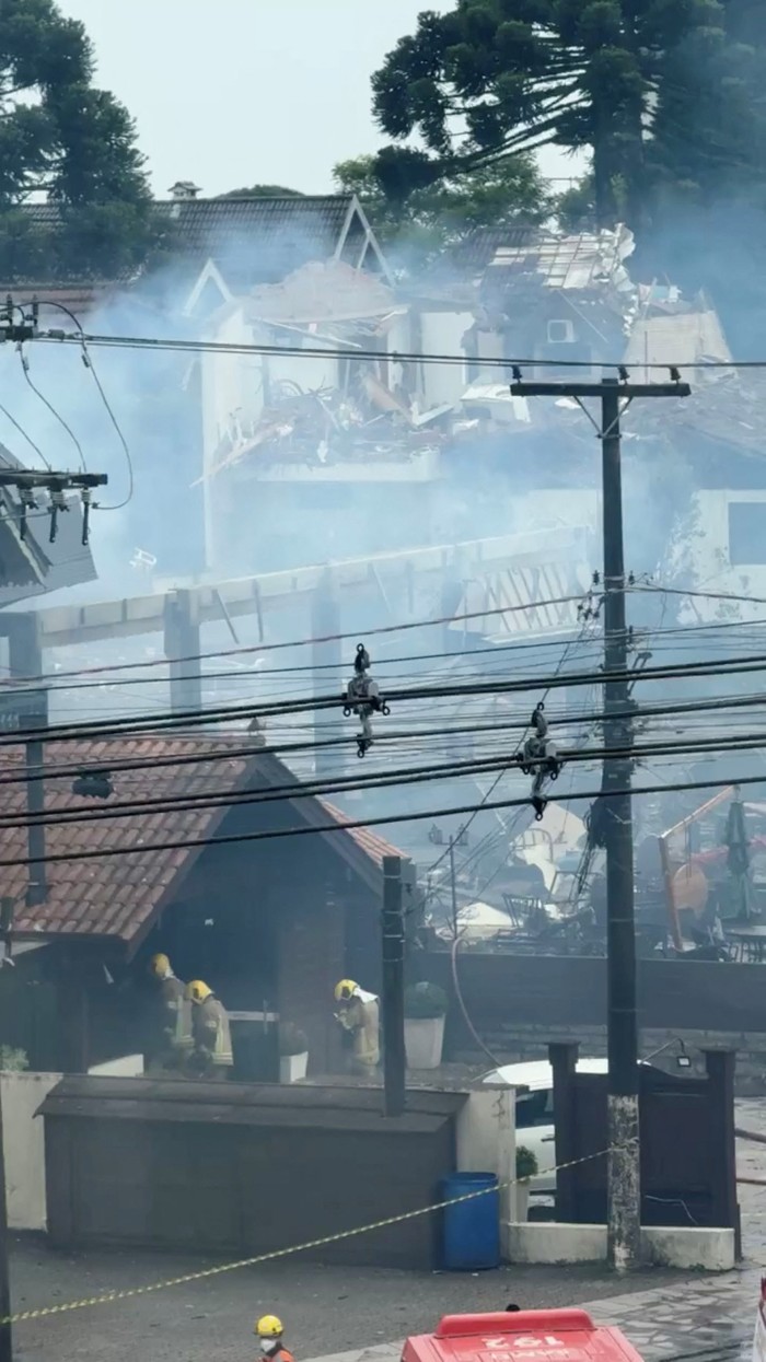 Firefighters work at the scene of damaged buildings, following a deadly small-plane crash, in the centre of Gramado, Rio Grande do Sul, Brazil, December 22, 2024 in this still image taken from social media video. Instagram @emanuelasampaio via REUTERS THIS IMAGE HAS BEEN SUPPLIED BY A THIRD PARTY. MANDATORY CREDIT. NO RESALES. NO ARCHIVES. VIDEO TAKEN THROUGH WINDOW.