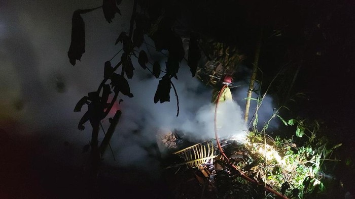 Petugas memadamkan api yang membakar kandang ayam.