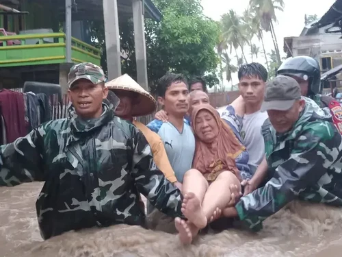 Petugas mengevakuasi lansia yang terjebak banjir bandang di Desa Soro, Kecamatan Lambu, Kabupaten Bima, NTB, Senin (23/12/2024) sore. (Foto: Dok. Istimewa)