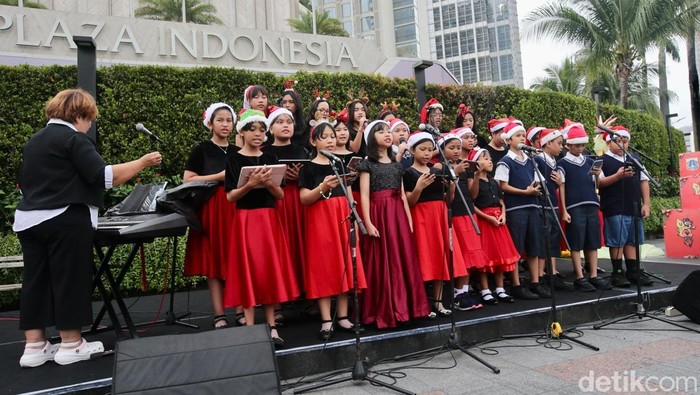 Sejumlah siswa/i melakukan Christmas Carol di kawasan Bundaran Hotel Indonesia, Jakarta, Senin (23/12/2024).