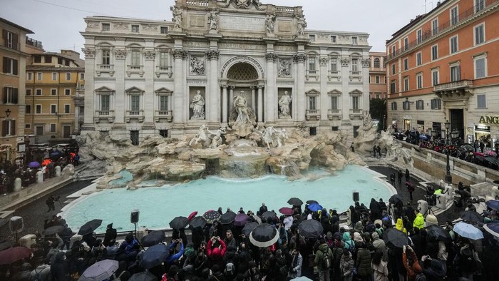 People admire the 18th century Trevi Fountain, one of Romes most iconic landmarks, as it reopens to the public after undergoing maintenance, just on time for the start of the Jubilee Year, an event expected to draw millions of visitors to the Eternal City, in Rome, Sunday, Dec. 22, 2024. (AP Photo/Andrew Medichini)